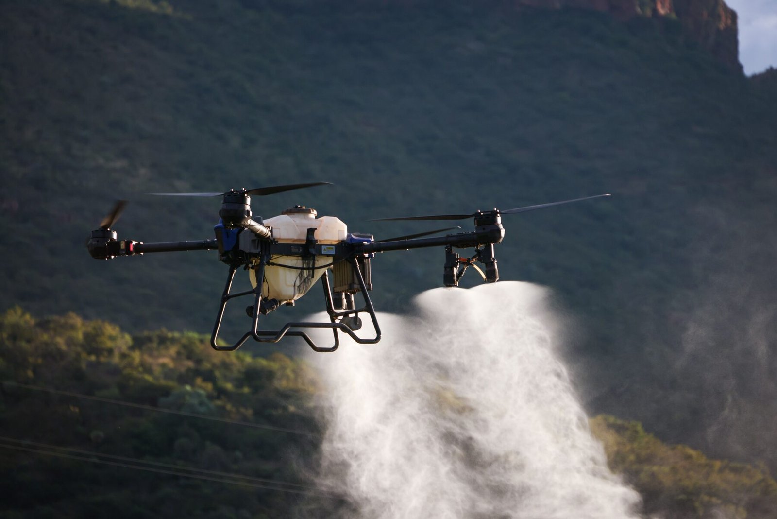 Poljoprivredni dron raspršuje tečnost iznad useva